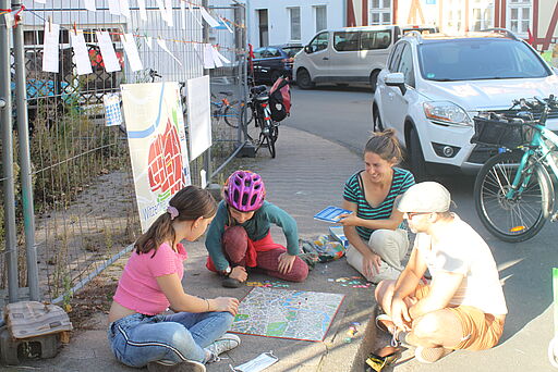 Brettspiele auf dem Bürgersteig der Spielstraße vor dem "Wunschzettelzaun"